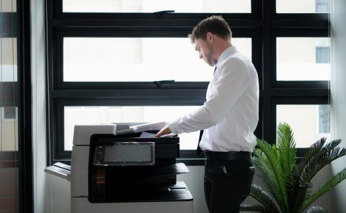 Businessman,In,Office,Working,With,Copier.